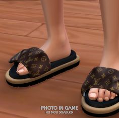 a person's feet wearing brown and black slippers with louis vuitton on them