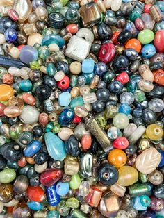 many different colored beads are stacked on top of each other in this pile, with one bead facing the camera