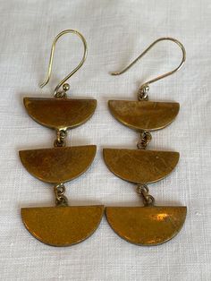 A pair of vintage brass dangle earrings. Cheap Brass Dangle Jewelry, Gold Drop Earrings With Antique Finish, Antique Gold Chandelier Earrings In Brass, Vintage Brass Clip-on Earrings For Gift, Gold Earrings With Antique Finish, Gold Metal Earrings With Antique Finish, Gold Antique Finish Metal Earrings, Handmade Vintage Brass Clip-on Earrings, Vintage Handmade Brass Clip-on Earrings