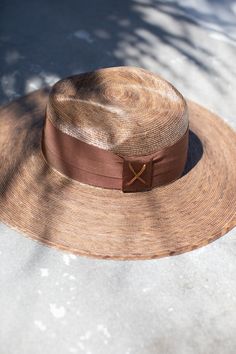 The most beautiful straw panama we've ever carried!! The glamorous Riviera hat is the perfect straw hat to offer full sun protection. Its body is braided by artisan hands and interlaced with palm leaves to create the finished design. Hat has a sealer on it making it water resistant. The construction of this hat is incredible. It’s completed with a rustic cotton braided trim. Features an inner elastic band for a OSFM fit! 100% Palm leaf, natural color (One Size) Standard Medium 58 cm Crown 4” Bri Luxury Fedora Straw Hat For Beach, Luxury Fedora Straw Hat For The Beach, Luxury Straw Hat With Short Brim For Beach, Luxury Short Brim Straw Hat For Beach, Luxury Short Brim Straw Hat For The Beach, Luxury Wide Brim Fedora For Beach, Luxury Wide Brim Fedora For The Beach, Luxury Brimmed Panama Hat For Beach, Luxury Curved Brim Sun Hat For Beach