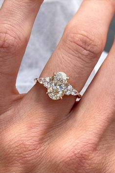 a woman's hand with a diamond ring on top of her finger and an engagement band