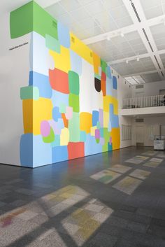 an empty room with colorful squares painted on the wall