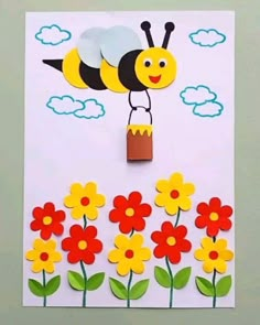 a card with flowers and a paper cut out of the shape of a bee on it