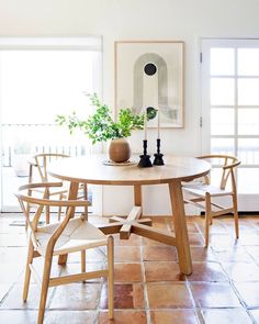 a table with chairs and a vase on it