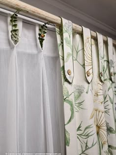 the curtains are closed and hanging in front of the window sill with green leaves on them