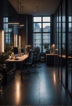 an office with large windows and desks in the dark, lit up by lights