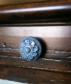 a close up of a door handle on a wooden cabinet