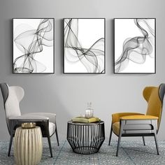 three abstract paintings hang on the wall next to two chairs and a table in a living room