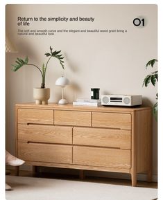 a wooden dresser sitting in front of a white wall with plants on top of it