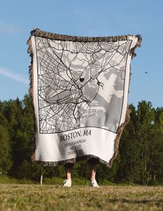 a person standing in front of a white blanket with the map of boston ma on it