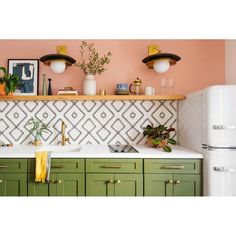 a kitchen with green cabinets and white appliances