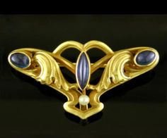 A beautiful Art Nouveau brooch with sapphires and a small pearl set amid flowing curves and draping acanthus leaves.  This intriguing jewel brings to mind an exotic moth spreading its wings in the night or, perhaps, a rare nocturnal flower opening into the moonlight.  A beautiful example of the Art Nouveau fascination with otherworldly, dream-inspired fantasy.  Created in 14kt gold, circa 1900. The reverse of the brooch is finely crafted with a sturdy framework supporting the flowing curves of t Art Nouveau Butterfly, Amethyst Brooch, Sapphire And Pearl, Antique Cufflinks, Bijoux Art Nouveau, Nouveau Jewelry, Acanthus Leaves, Light Amethyst, Antique Brooches