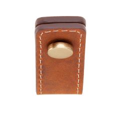 a brown leather case with a metal button on the front and white stitching around it