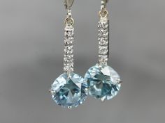 "These lovely zircons are bright and bold! The color is cool, luscious sky blue, with plenty of sparkles! The long bar at the center is inlaid with sparkling diamonds, at the very top are the earring wires, hinged lever backs which are brand new, 14K white gold with a simple polished design. These are comfortable to wear and very secure! Metal: 14K White Gold Gem: 2 Blue Zircon totaling 6.81 Carats Gem Measurements: 8.2 mm, Round Accents: 10 Diamonds totaling .10 Carats, F in Color, VS in Clarit Drop Earrings Bridal, White Gold Drop Earrings, Beautiful Tiaras, Edwardian Jewelry, Earring Wires, Cameo Ring, Fabulous Jewelry, Blue Zircon, Gold Drop Earrings