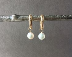 ✦These pearl hoop earrings are perfect for any occasion!  Natural round white freshwater pearls dangle from huggie hoops. The hoops have a hinge on the ear wire to make them easy to put on and take off, as well as ensure they are securely attached to the earlobes.  ✦Pearls: Natural round creamy white freshwater pearls, 6.5-7 mm. These are high-quality pearls with excellent luster! ✦Ear wires: 14k gold-filled huggie latching hoops, 15mm diameter. ✦The length of each earring is 1 inch. ✦Click here to see these in a smaller, 12mm, size huggie hoop: https://www.etsy.com/listing/830852702 ✦Also available in sterling silver https://www.etsy.com/listing/783315003 and rose gold-filled https://www.etsy.com/listing/783320087. ✦Your jewelry will be packaged in a beautiful and reusable organza bag. Al Dainty White Round Huggie Earrings, White Huggie Earrings For Everyday, Classic White Huggie Earrings As Gift, Classic White Huggie Earrings For Gift, Classic White Huggie Earrings For Everyday, Everyday White Pearl Drop Huggie Earrings, White Round Hoop Earrings With Lever Back, White Small Hoop Huggie Earrings As A Gift, Classic White Hypoallergenic Hoop Earrings