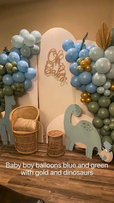 baby boy balloons blue and green with gold and dinosaurs on display in the living room