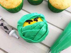 cupcakes with green icing and yellow frosting in the shape of a ninja face