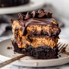 a piece of cake with chocolate frosting and peanut butter on top is sitting on a plate