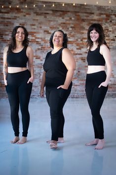 three women in black clothing standing next to each other with their hands on their hips