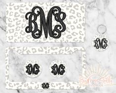 the monogrammed decals and earring set are shown on a marble surface