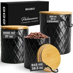 three black canisters with wood lids and labels on them, one has coffee beans in it