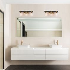 a bathroom with two sinks and a large mirror