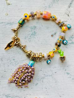 Boho bracelet -glass Czech beads -brass finishings -evil eye handmade glass beads -Brass cap beads -Natural Yellow Opal Rondelle -Enamel catua charm -Gold charm -7.2 inches Bohemian Bracelets With Dangling Beads, Artisan Beaded Bracelets With Dangling Beads, Bohemian Bracelets With Dangling Beads For Festivals, Bohemian Bracelets With Dangling Beads For Gift, Bohemian Festival Bracelets With Dangling Beads, Bohemian Gold Bracelets With Dangling Beads, Bohemian Beaded Bracelets With Dangle Spacer Beads, Eclectic Gold Beaded Bracelets, Adjustable Bohemian Gold Beads