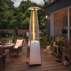 a patio heater sitting on top of a wooden deck next to a table and chairs