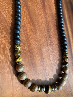 This stunning beaded necklace features an array of Tiger's Eye stones that are sure to turn heads. The warm, earthy tones of the stones are complemented by the delicate beads that make up the chain. The necklace is perfect for dressing up any outfit and is versatile enough to be worn to work or out on the town. Each stone is unique, making this necklace a one-of-a-kind piece. The necklace is made of high-quality materials, ensuring that it will last for years to come. Elegant Beaded Necklaces For Meditation, Elegant Beaded Necklace For Meditation, Earthy Long Adjustable Beaded Necklace, Amber Beaded Necklace For Meditation, Earthy Healing Beads, Adjustable Long Beaded Necklace With Natural Stones, Artisan Amber Beaded Necklace With Adjustable Fit, Brown Polished Beads Necklace As A Gift, Earthy Gemstone Beads Necklaces For Healing