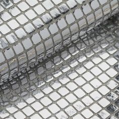 a piece of metal mesh with white squares on it