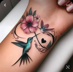 a hummingbird and flower tattoo on the leg with hearts in the center, surrounded by flowers