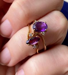 Please note that this listing is for 1 ring only... the TOP ring in the photo. The marquis ring has SOLD, the photo is showing how the ring looks on the finger. Loving those juicy rich purple tones lately. Sweet vintage amethyst gold ring. Circa 1970s - 1980s or so.  Signed 10K Magic Glo inside the shank. Central oval stone tests as amethyst on my gem tester, it's faceted and oval in shape. Measures approx 8 x 5 mm. Set at a slight angle or diagonal. Two little sparkly white stones to either side of the amethyst. I didn't get a diamond reading on these but they're very small and hard to test. Could possibly be white topaz or something similar. Ring sits up approx 7 mm total height.  10K yellow gold. Weighs 1.92 grams. Size 6.75 US resizable.  In very good used vintage condition. For 1 ring Fine Jewelry Pear-shaped Hallmarked Rings, Hallmarked Marquise Ring For Anniversary, Marquise Cut Hallmarked Promise Ring, Purple Marquise Cut Promise Ring, 14k Gold Marquise Rings Hallmarked, 17 Jewels Marquise Ring For Anniversary, Anniversary Gemstone Bypass Ring, Vintage Marquise Cut Rings With Accent Stones, Vintage Marquise Cut Ring With Accent Stones