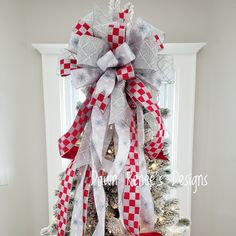 a christmas tree decorated with red and white ribbons