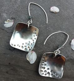 "Stylish sterling silver squares, domed and patterned with \"holes\", hang from handmade earwires. The silver squares are 2cm in length and width. The total length from the top of the earwires is 5cm. Each earring has an added sparkle from a grey swarovski crystal." Nickel-free Silver Square Pendant Earrings, Square Sterling Silver Earrings, Silver Square Metal Earrings, Silver Sterling Silver Square Pendant Earrings, Silver Hammered Rectangular Earrings, Silverware Crafts, Beachglass Jewelry, Jewelry Making Necklace, Necklace Pendants