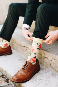 the man is tying his shoes before going down the flight of stairs with flowers on them