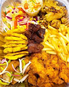 a tray full of food including fries, meat and coleslaw is on the table