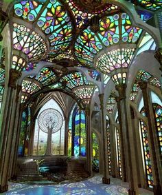 the inside of an ornate building with stained glass windows and arches on each side,