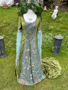 THIS STUNNING ENCHANTED ORIGINAL HAND CRAFTED DRESS HAS BEEN  FASHIONED  IN THE PRINCESS LINE STYLE  IT IS MADE FROM IN A LUXURIOUS TRULY GORGEOUS MOSS GREEN CRUSHED VELVET  (CONTAINING LYCRA) ...    IDEAL FOR  A  MEDIEVAL / RENAISSANCE THEMED BALL, PARTIES, BELTANE SAMHAIN , HANDFASTINGS / WEDDINGS, OR ANY SPECIAL, SACRED OCCASION, FOR THAT EXTRA WOW FACTOR   MEDIEVAL STYLE SLEEVES HAVE BEEN FASHIONED FROM A STUNNING  BREATHTAKINGLY BEAUTIFUL EMBROIDERED FINE GREENY BLUE  TULLE WITH A STUNNING Floor-length Elven Medieval Dress For Larp, Fitted Fairycore Medieval Dress Costume, Bohemian Costume Dress With Historical Design, Bohemian Fitted Medieval Dress For Festivals, Bohemian Medieval Dress For Costume Festivals, Bohemian Dresses For Larp And Medieval Festivals, Bohemian Medieval Dress For Larp And Festivals, Bohemian Dress With Historical Design For Costume, Bohemian Historical Costume Dress