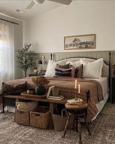 a bedroom with a bed, table and two baskets on the floor next to it