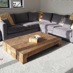 a living room filled with furniture and a wooden coffee table in front of a window