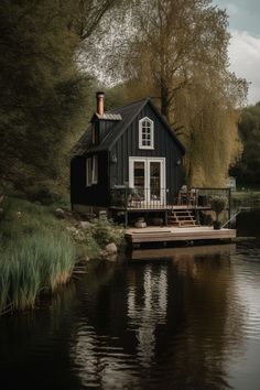 a house sitting on top of a lake next to a forest