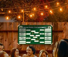 a group of people standing around each other in front of a sign that says beer pong tournament