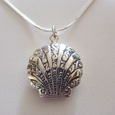 Locket Details: This shell locket is made of genuine 925 Sterling Silver Stamped 925 Holds two photos Includes 18" 925 Sterling Silver snake chain with spring ring clasp Measurements: 25mm x 22mm x 8mm (1" x 7/8" x 5/16") Arrives in a gift box Shipping Details: All orders are shipped within 1 business day (excluding US Holidays) All orders are shipped from Texas, USA International Buyers: Please see Shipping & Payments tab regarding Customs Fees Return Details: Risk-Free 30-Day Return Policy Customer Service: 9am to 4pm CST Monday-Friday (excluding US Holidays) Please message us with any questions! Engraved Pendant Necklace For Beach, Adjustable Engraved Necklaces For Beach, Adjustable Engraved Necklaces For The Beach, Silver Engraved Necklace For Beach, Handmade Sterling Silver Locket Necklace, Elegant Adjustable Silver Locket Necklace, Silver Shell Jewelry With Lobster Clasp, Handmade Adjustable Silver Locket Necklace, Silver Shell-shaped Jewelry With Lobster Clasp