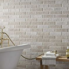 a white bath tub sitting next to a wooden table