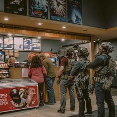 some people are standing in line at a food court and one person is wearing an army uniform