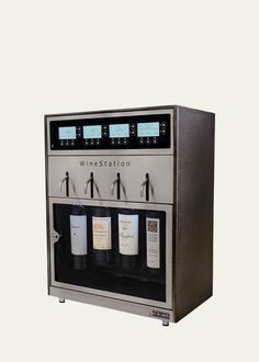 a wine dispenser is shown with three bottles in front of the machine