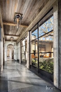 the inside of an old building with lots of windows and plants in front of it