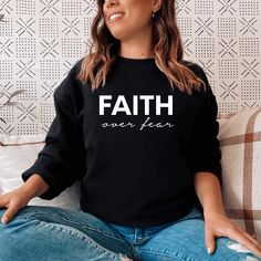 Keep warm and comfortable in this Faith Over Fear Sweatshirt. This cool Christian sweatshirt is soft, stylish, and sure to keep you warm in the colder months. It's versatile to wear for a day outdoors, heading to the gym, or a lazy day watching movies on the couch. Wearing Christian hoodies and sweatshirts can be a subtle way to express your faith and create conversations with anyone and be a gentle reminder to encourage you in any season. They can also spread encouraging words of faith everywhe Comfortable Black Long Sleeve Sweater, Comfy Black Sweatshirt For Loungewear, Black Relaxed Fit Comfortable Sweater, Black Comfortable Relaxed Fit Sweater, Comfy Black Crew Neck Sweatshirt, Comfy Long Sleeve Black Sweatshirt, Comfy Black Long Sleeve Sweatshirt, Cozy Black Sweats For Fall, Comfy Black Top For Fall