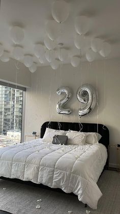 a bed in a room with balloons hanging from the ceiling and numbers on the wall