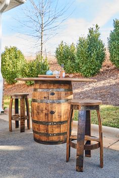 an outdoor table and stools made out of wine barrels